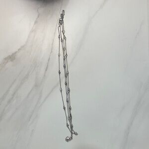 Silver colored long BaubleBar necklace with crystals.